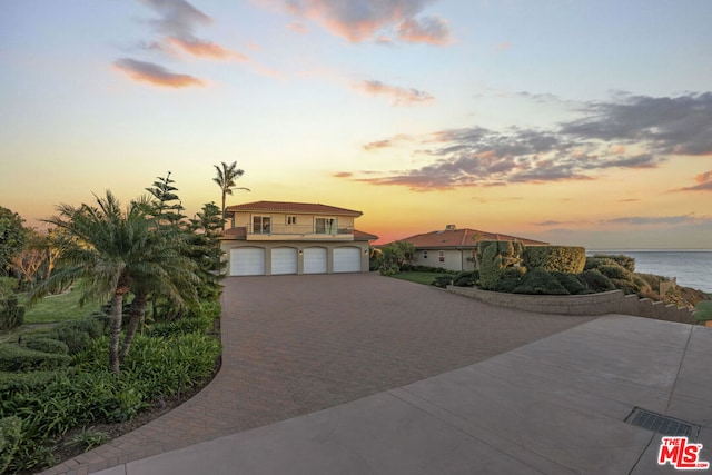 view of front of property with a garage and a water view