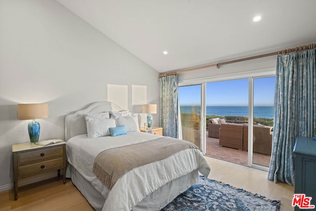 bedroom with a water view, vaulted ceiling, access to outside, and light wood-type flooring