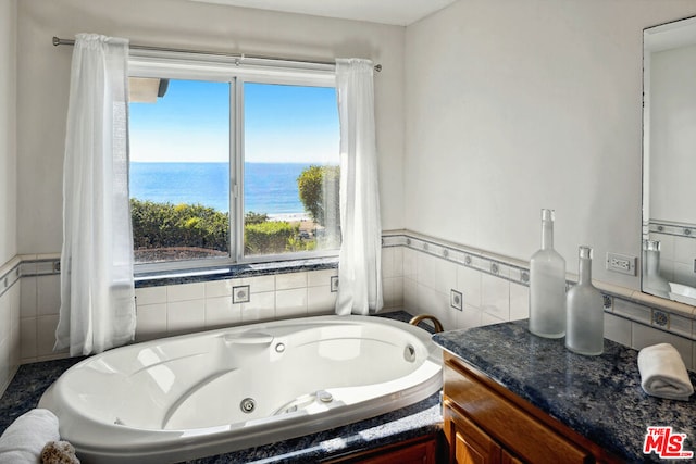 bathroom with vanity, a water view, plenty of natural light, and a bathtub