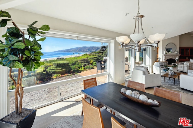 dining room with wood-type flooring, a water and mountain view, and a chandelier