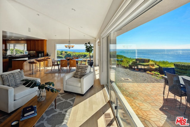 living room featuring a water view, a chandelier, high vaulted ceiling, and hardwood / wood-style flooring