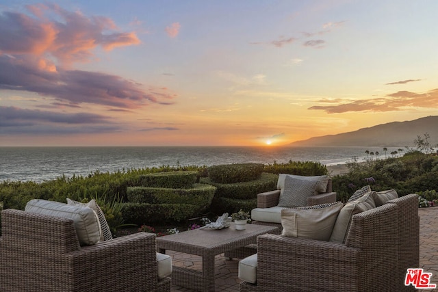 patio terrace at dusk with a water and mountain view