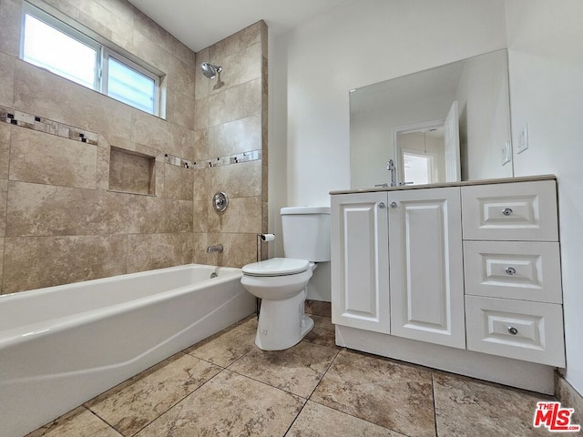 full bathroom featuring tiled shower / bath combo, toilet, and vanity