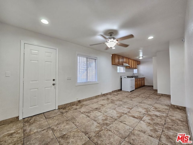 kitchen featuring white range oven, ceiling fan, and sink