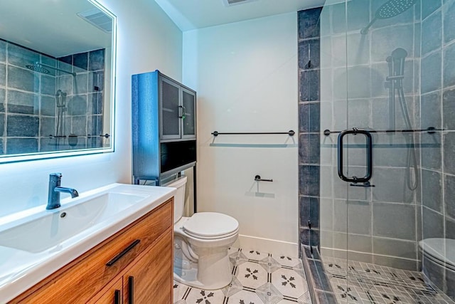 bathroom featuring tile patterned floors, vanity, a shower with shower door, and toilet