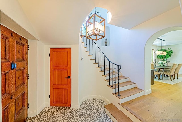 stairs featuring hardwood / wood-style floors and vaulted ceiling