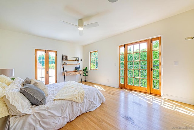 bedroom with access to exterior, ceiling fan, multiple windows, and light wood-type flooring