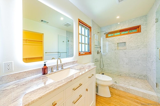 bathroom with vanity, toilet, a shower with shower door, and wood-type flooring