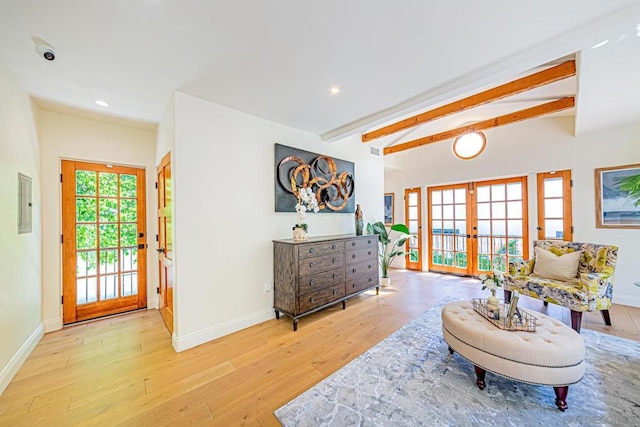 sitting room with beam ceiling, light wood-type flooring, electric panel, and french doors