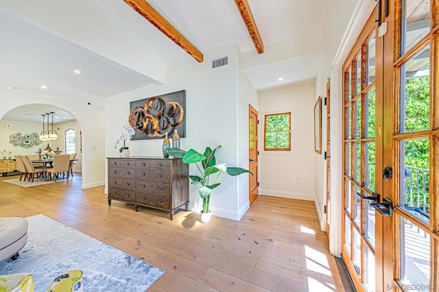 foyer entrance featuring beamed ceiling, light wood-type flooring, and french doors