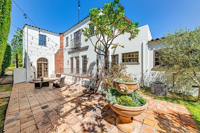 rear view of house featuring outdoor lounge area, french doors, a patio, and central AC unit