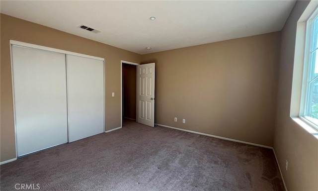 unfurnished bedroom featuring a closet and carpet flooring