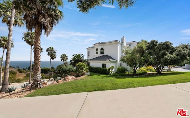 view of home's exterior featuring a water view and a yard