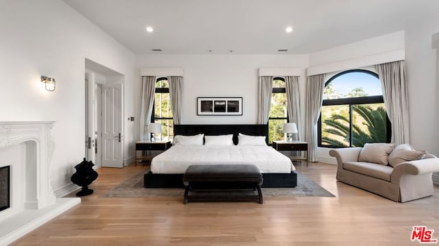 bedroom featuring multiple windows and light hardwood / wood-style flooring