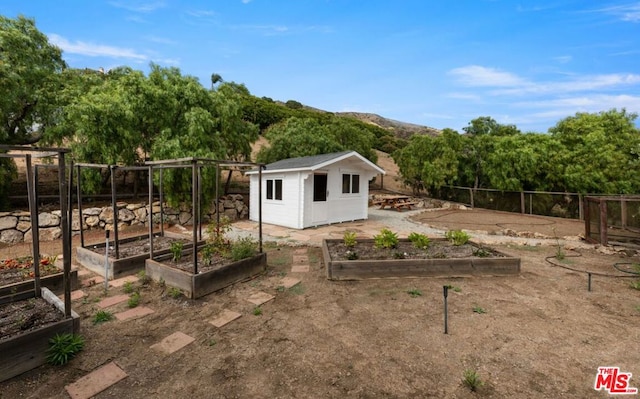 view of yard featuring a mountain view and a storage unit