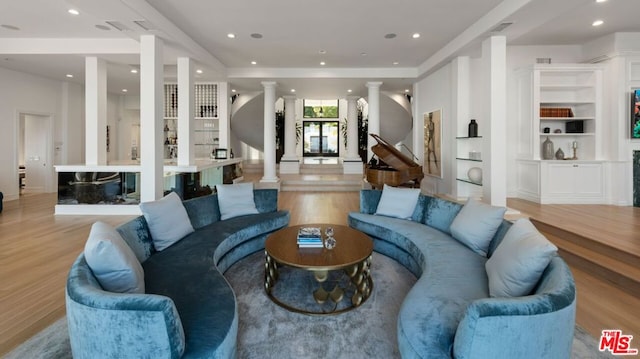 living room with light hardwood / wood-style floors and built in shelves