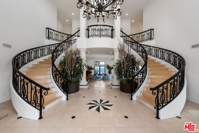 tiled entryway featuring a towering ceiling and ornate columns