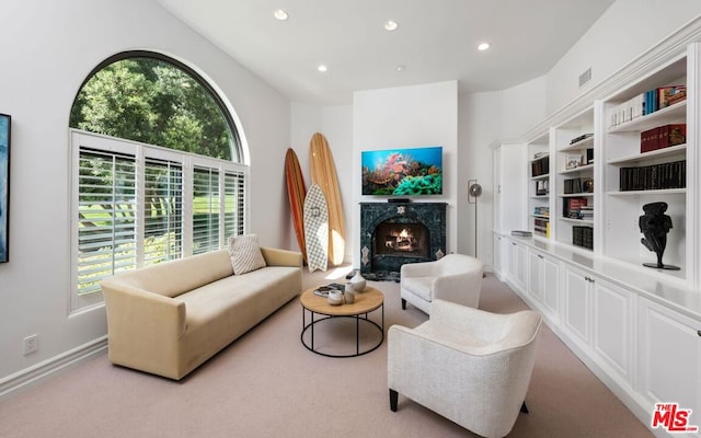 carpeted living room featuring a wealth of natural light and a high end fireplace