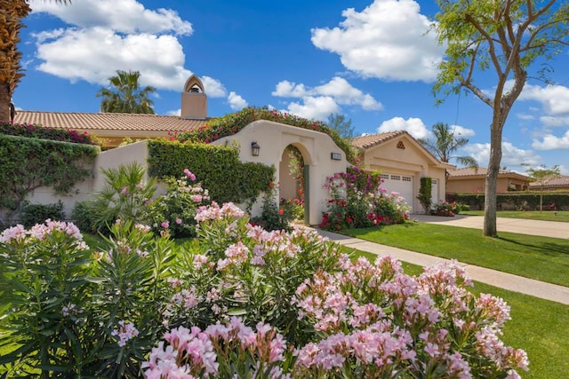 mediterranean / spanish house with a front lawn and a garage