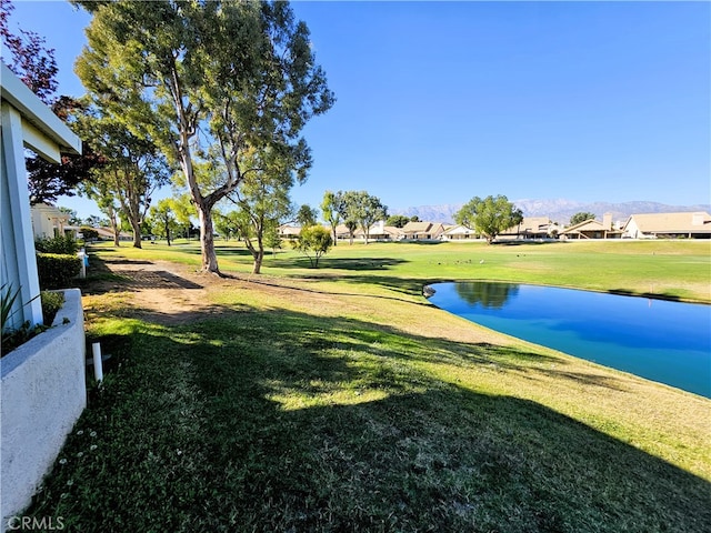 view of property's community with a water view and a yard