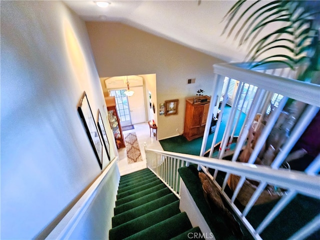 stairs featuring vaulted ceiling