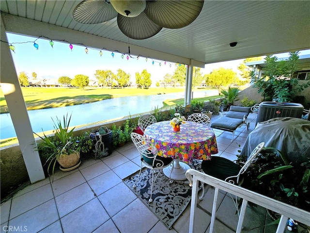 view of patio / terrace featuring ceiling fan, cooling unit, and a water view