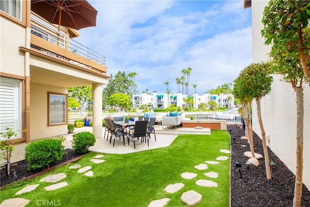 view of yard with an outdoor living space, a balcony, and a patio