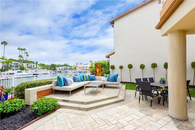 view of patio with an outdoor living space and a water view