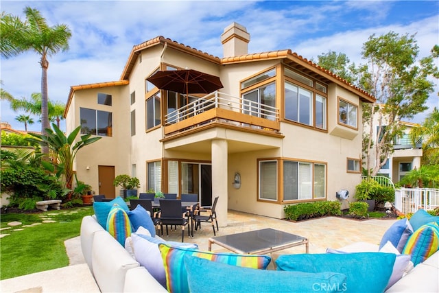 rear view of property featuring a patio area and a balcony