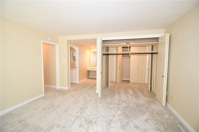 unfurnished bedroom with light carpet and a closet