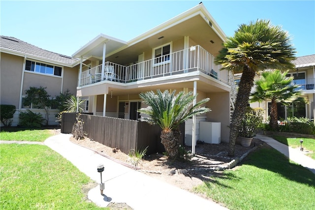 view of front facade with a balcony and a front lawn