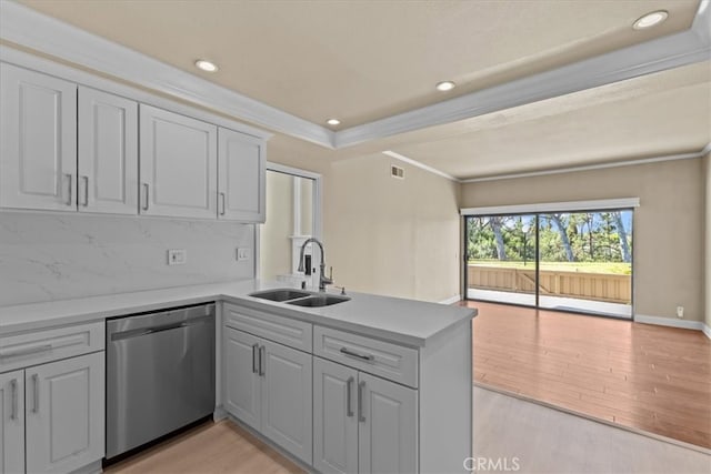 kitchen featuring light hardwood / wood-style floors, backsplash, kitchen peninsula, stainless steel dishwasher, and ornamental molding