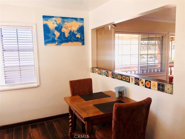 dining area with ornamental molding, dark hardwood / wood-style floors, and a healthy amount of sunlight