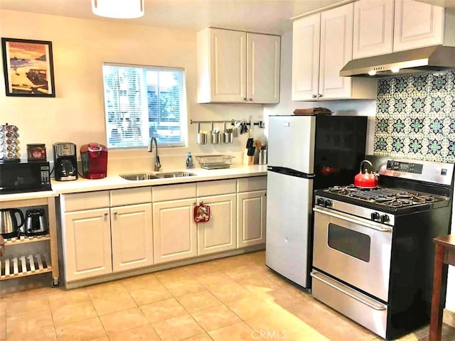 kitchen with light tile patterned flooring, white cabinetry, backsplash, stainless steel range with gas cooktop, and sink