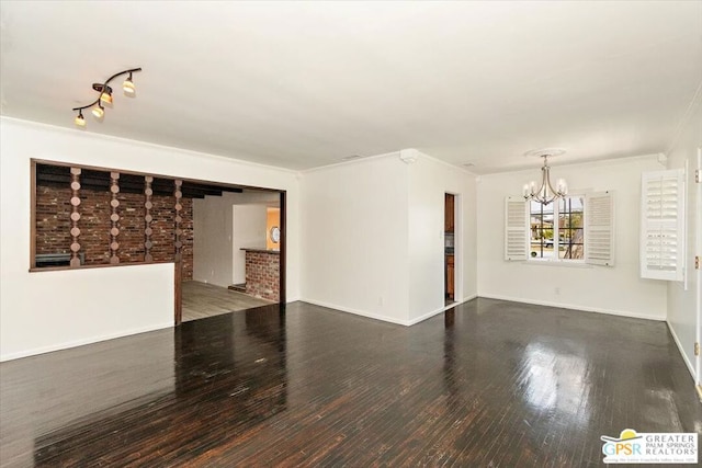 empty room featuring a notable chandelier, dark hardwood / wood-style floors, and ornamental molding