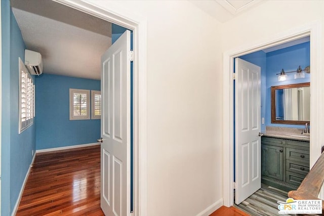 hall with wood-type flooring and a wall mounted air conditioner