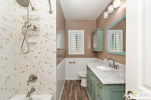 full bathroom featuring a healthy amount of sunlight, vanity, toilet, and hardwood / wood-style flooring