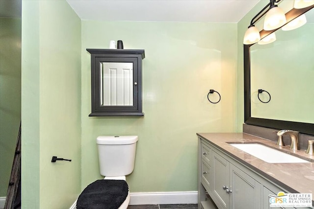 bathroom with tile patterned flooring, vanity, and toilet