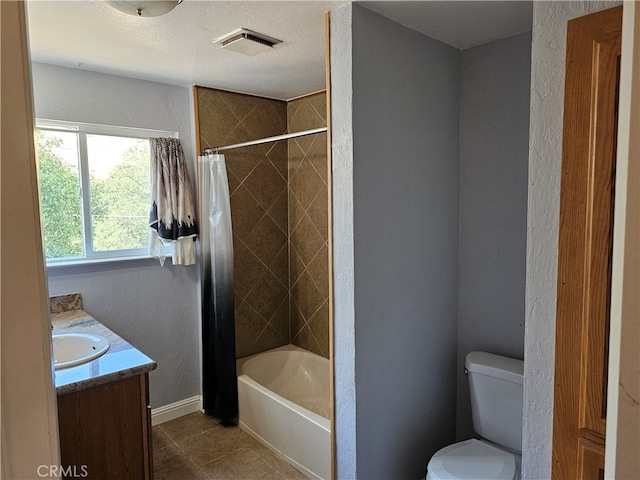 full bathroom featuring tile patterned floors, toilet, shower / bath combination with curtain, vanity, and a textured ceiling