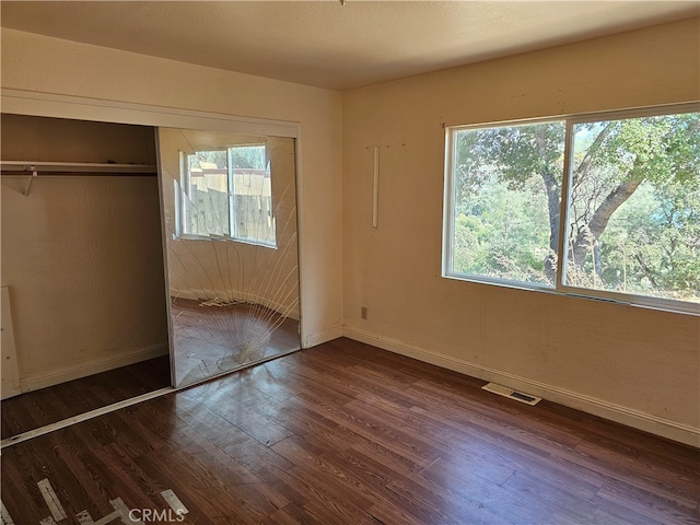 unfurnished bedroom with a closet and dark hardwood / wood-style floors