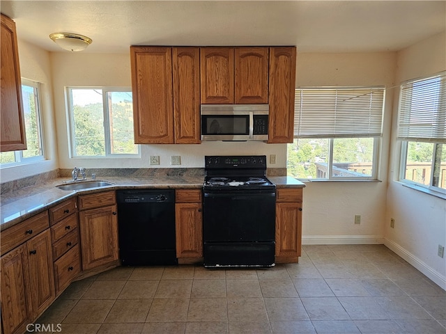 kitchen with light tile patterned floors, black appliances, and sink