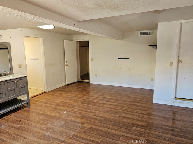 spare room featuring a textured ceiling, sink, and wood-type flooring