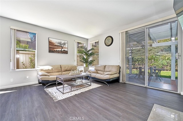 living room with dark wood-type flooring and a healthy amount of sunlight