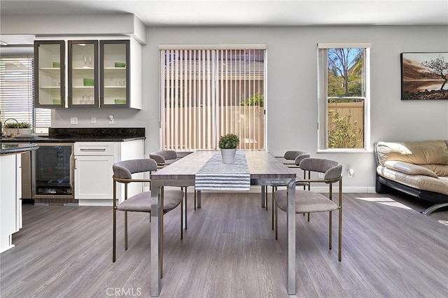 dining room with bar area and light hardwood / wood-style flooring