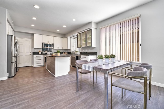 kitchen featuring white cabinetry, a kitchen island, stainless steel appliances, a textured ceiling, and dark hardwood / wood-style floors