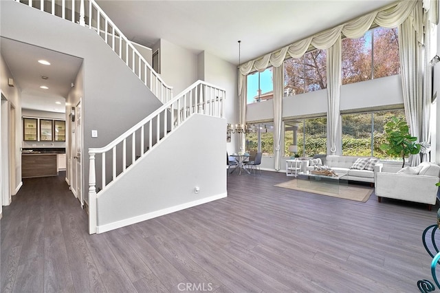 unfurnished living room with a high ceiling and dark wood-type flooring