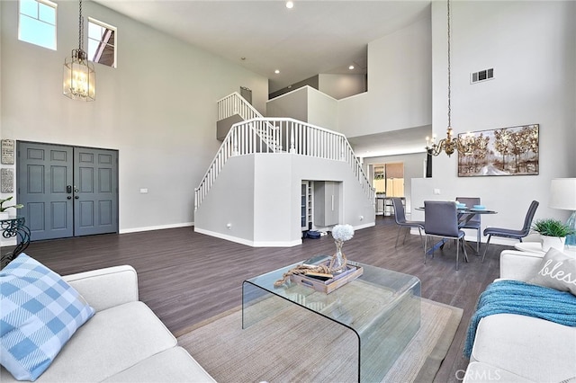 living room with high vaulted ceiling, a chandelier, and dark wood-type flooring