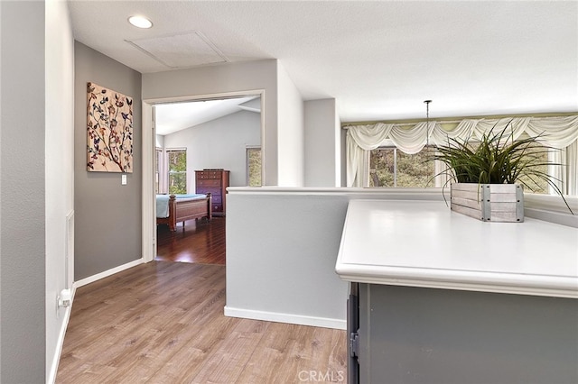 hall with lofted ceiling and hardwood / wood-style flooring