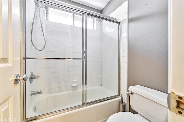 bathroom with bath / shower combo with glass door and toilet