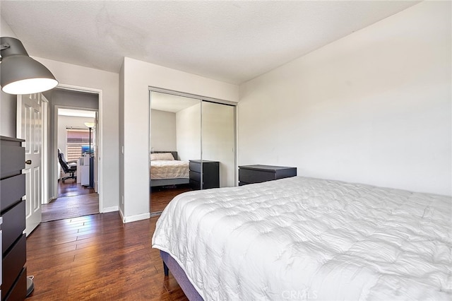 bedroom featuring a closet, dark wood-type flooring, and a textured ceiling